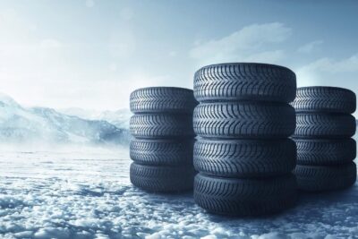 Foto con tres columnas de neumáticos apilados sobre la nieve.