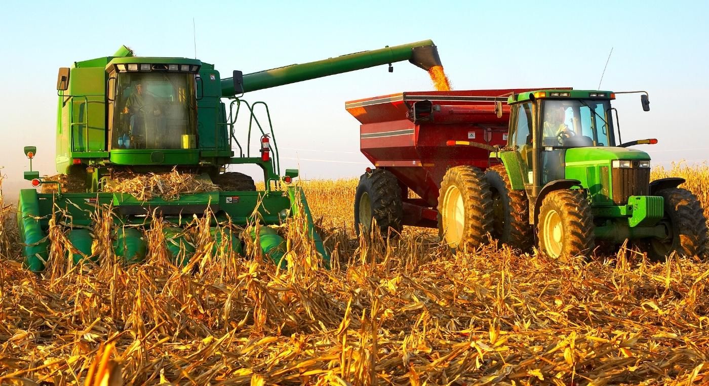 Foto de un tractor y una cosechadora trabajando en el campo.